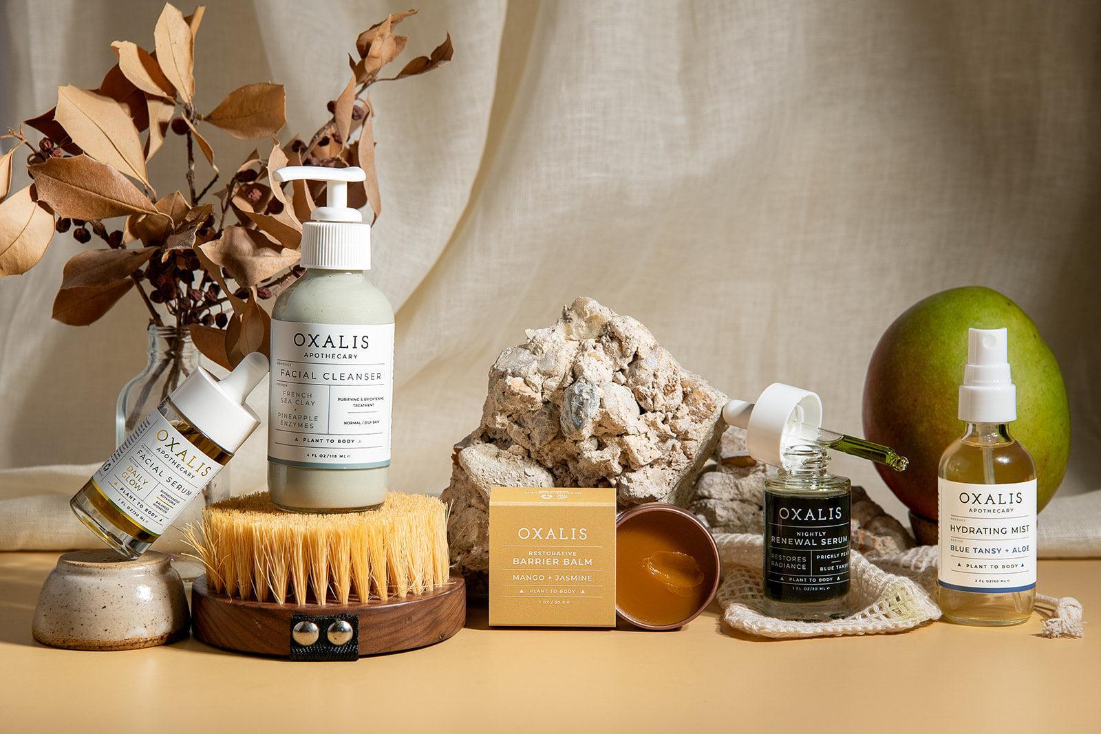 Oxalis Apothecary plant-powered skincare ritual featuring French Sea Clay Facial Cleanser, Daily Glow Facial Serum, Nightly Renewal Serum, Restorative Barrier Balm, and Blue Tansy Hydrating Mist.